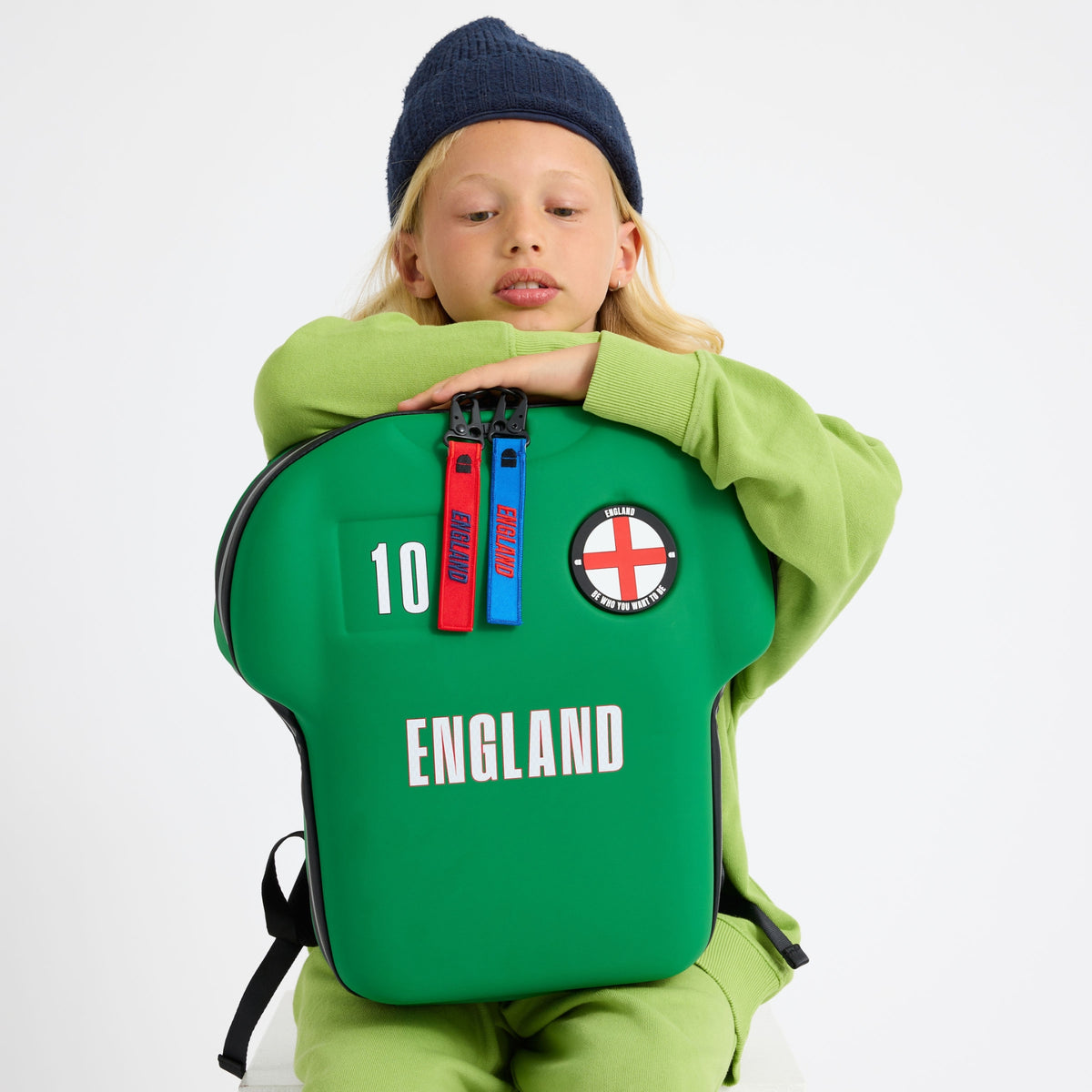 kid holding a green backpack with England design on a white background