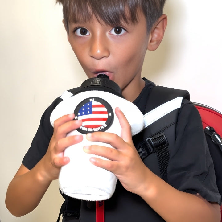 Child holding a white object with an American flag design against a plain background
